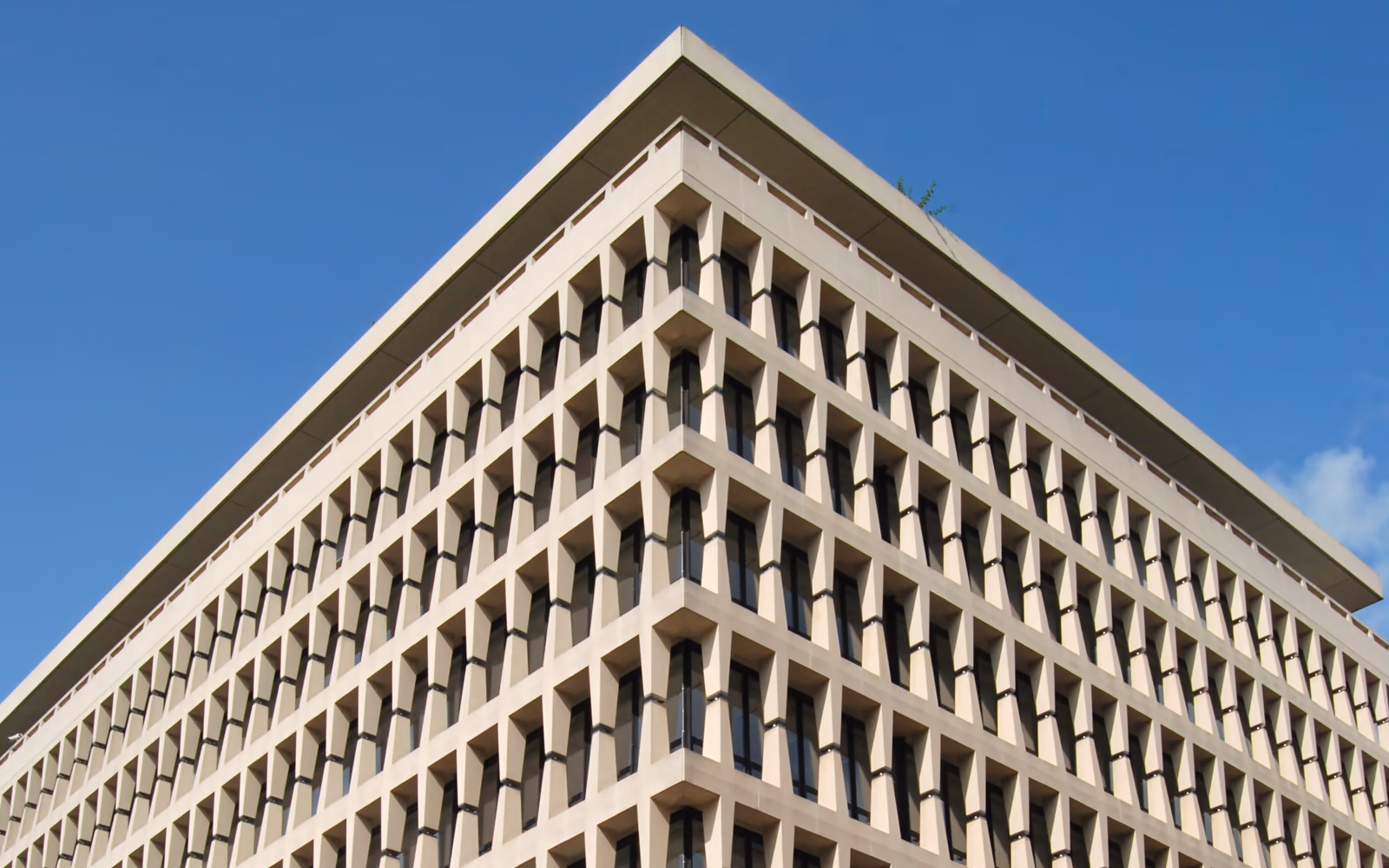 Angle de l'ancien siège de la Banque Lambert, avenue Marnix à Bruxelles, façade fonctionnaliste de Gordon Bunshaft contre un ciel bleu.